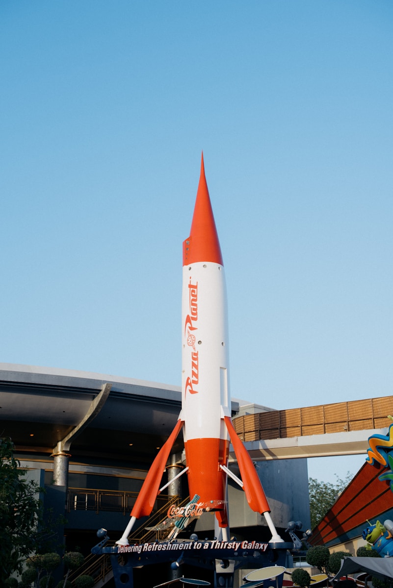 an orange and white rocket sitting on top of a building