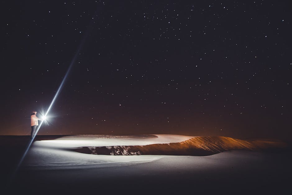 Person with flashlight stargazing in Cidreira, Brazil under a clear night sky.