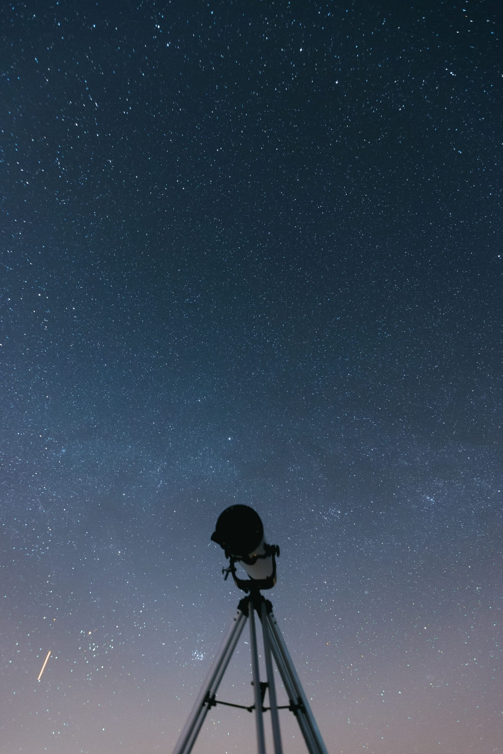 Silhouette of a telescope under a star-filled night sky. A perfect shot for astronomy enthusiasts.